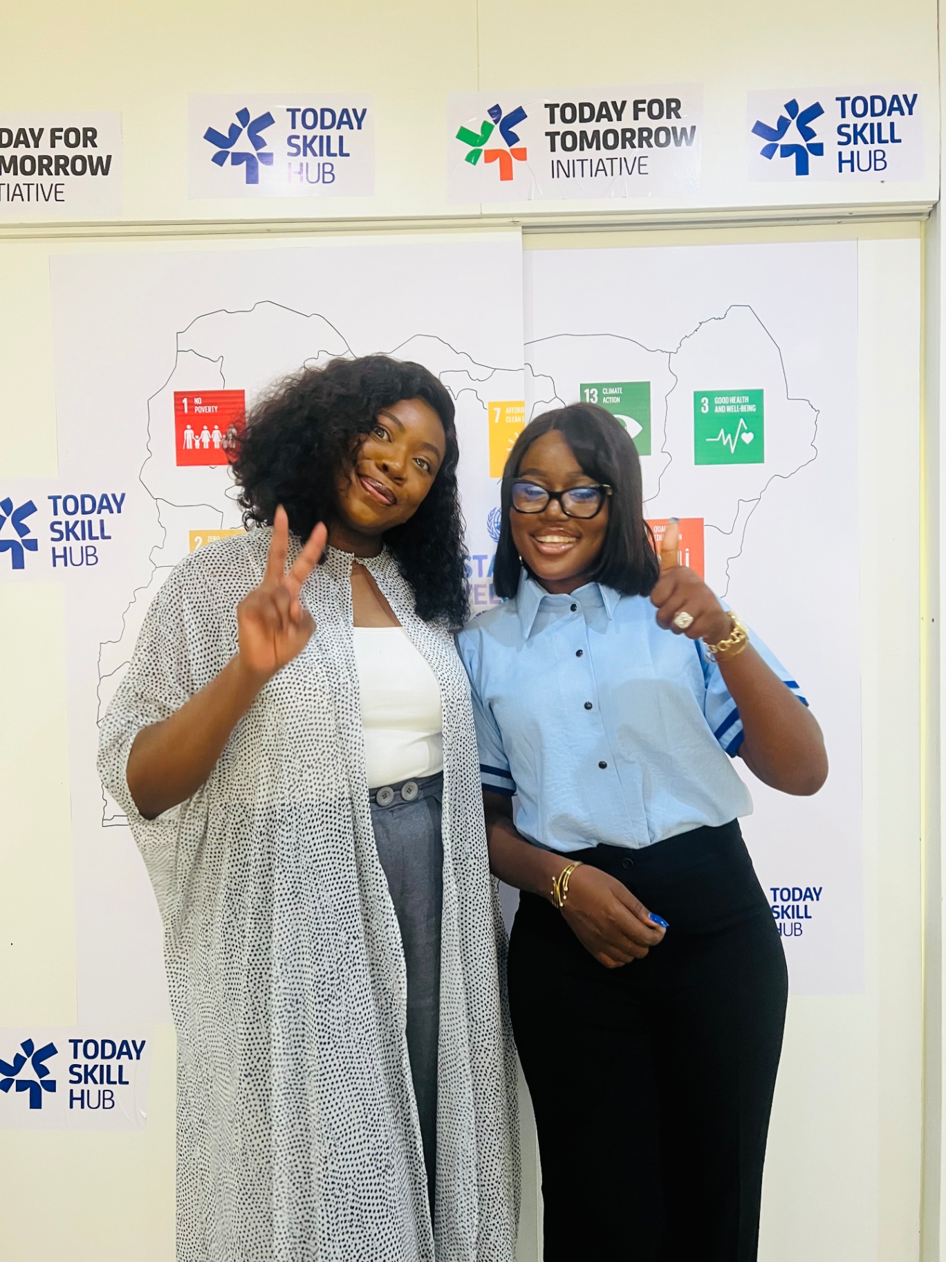 Two graduates celebrating at the TFT-TSH backdrop